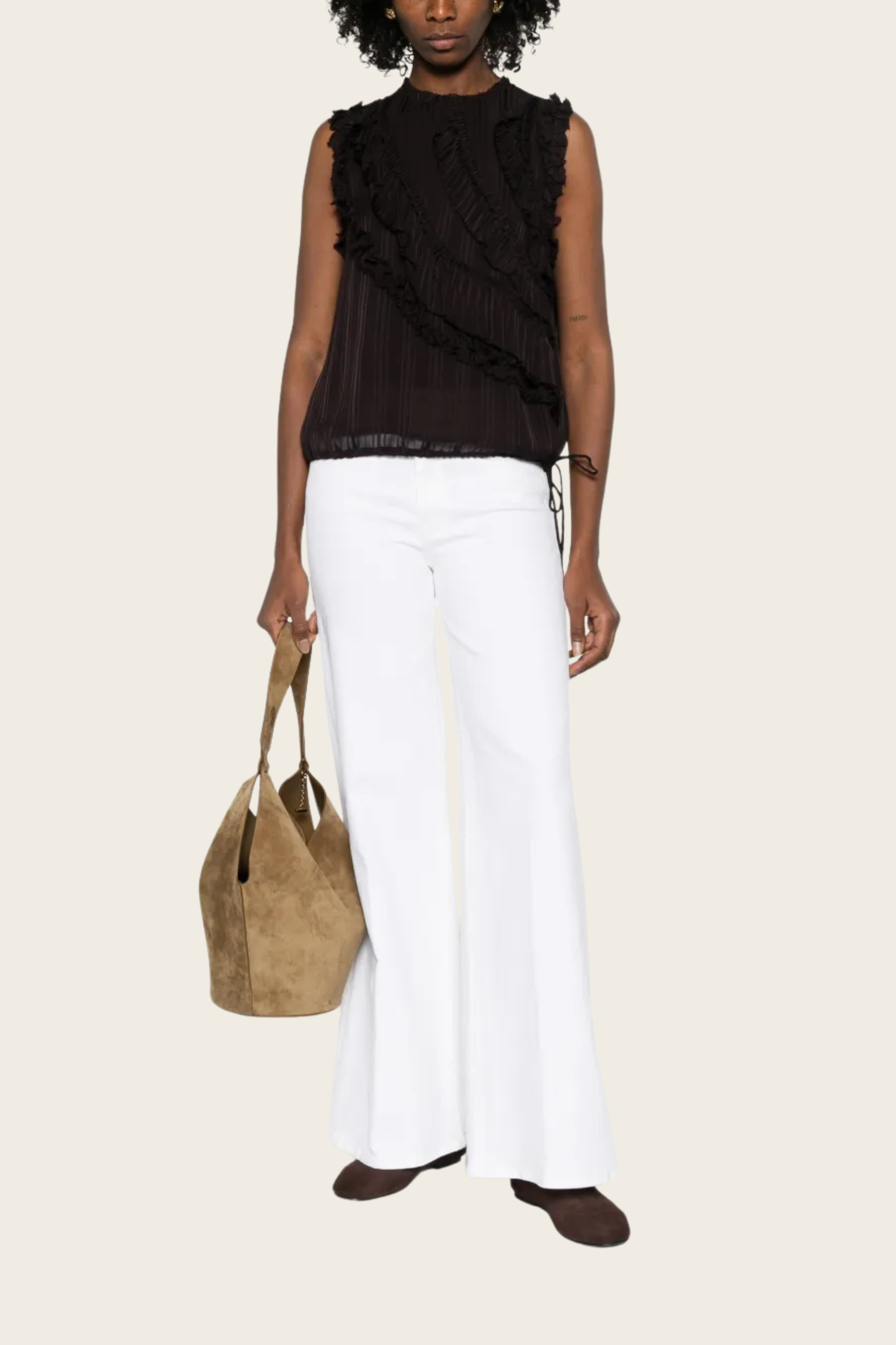 White twister jeans by Mother, styled with a dark sleeveless top and brown suede bag.