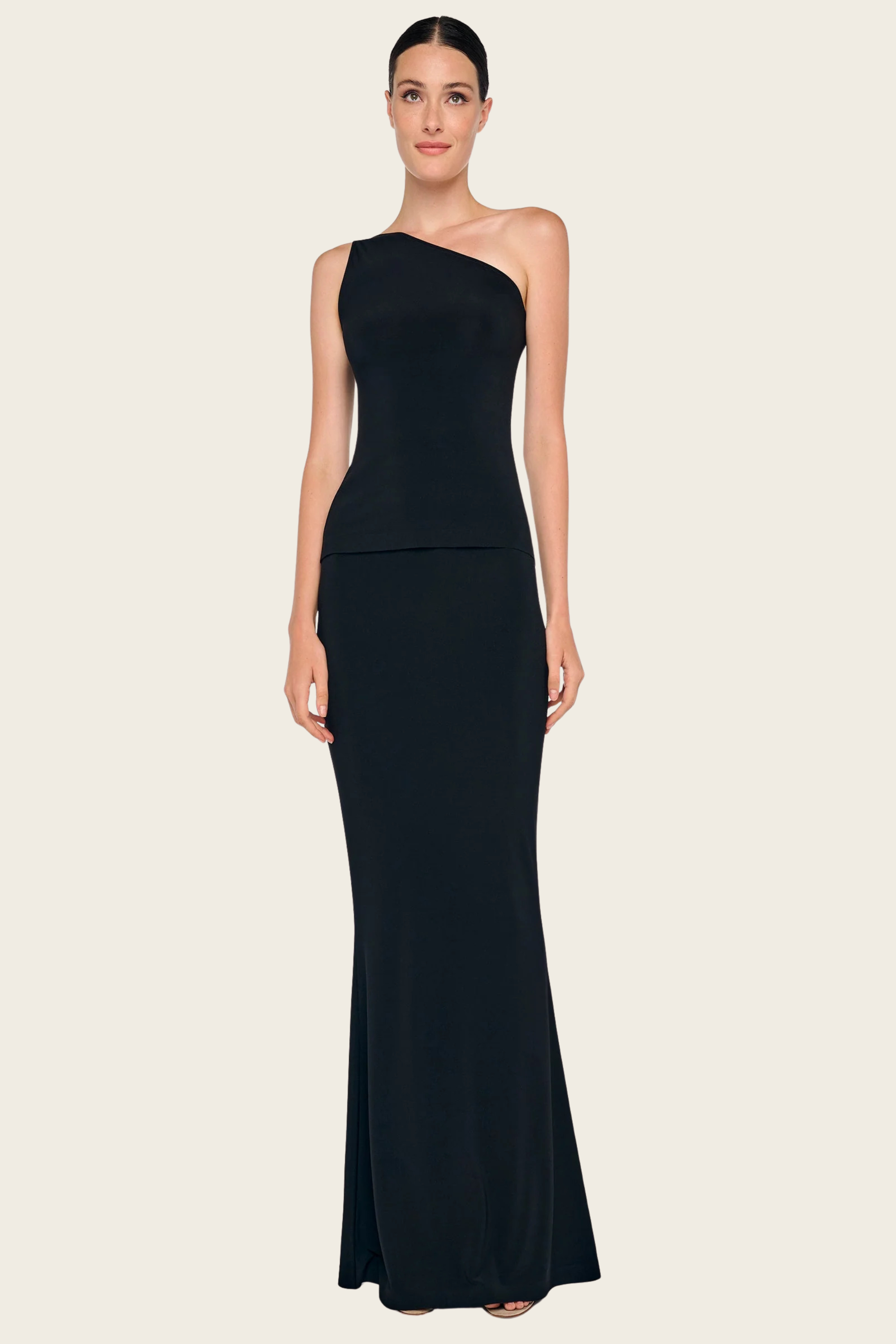 Black one-shoulder dress by Norma Kamali with a fitted silhouette and long skirt.