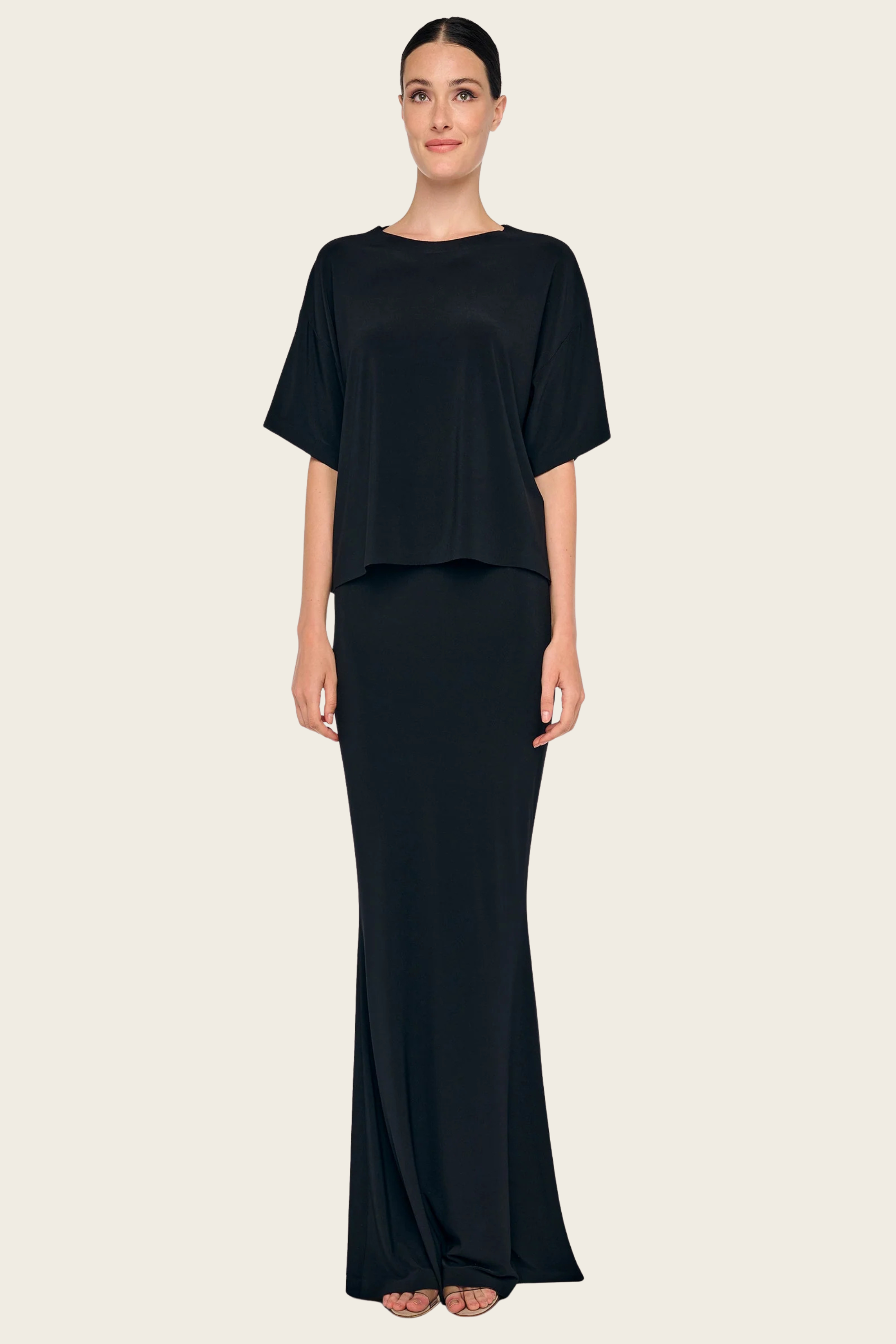 Black shirt by Norma Kamali in a boxy style, paired with a matching maxi skirt.