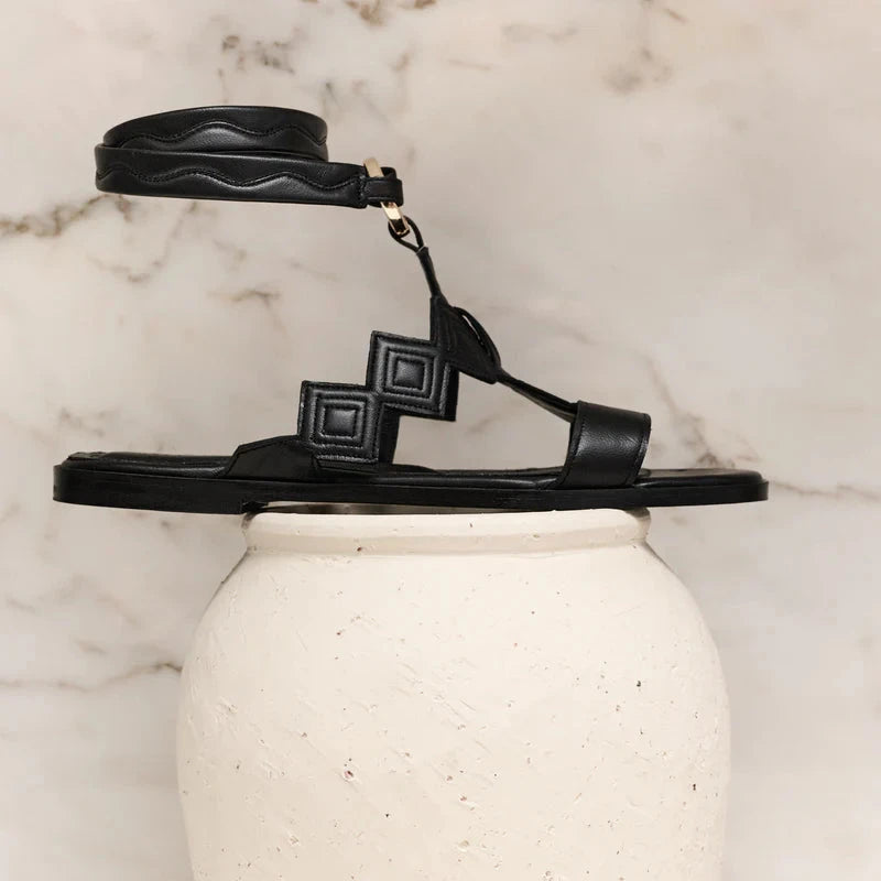 Black Marsilia sandal by Di Gaia, side view with geometric straps and a wave-pattern ankle strap - espace cannelle
