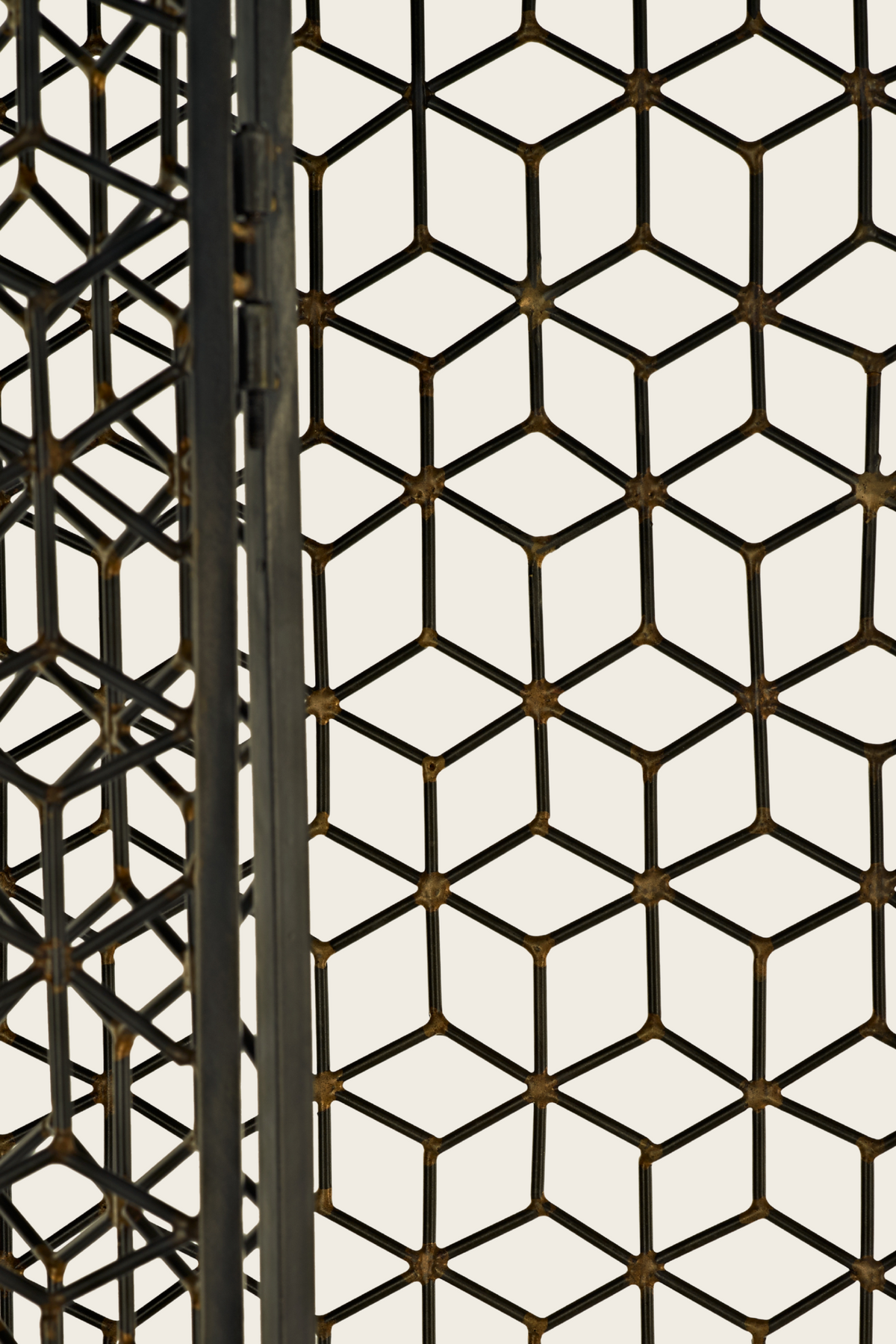 Close-up of the folding screen’s black geometric lattice and gold-tone joints