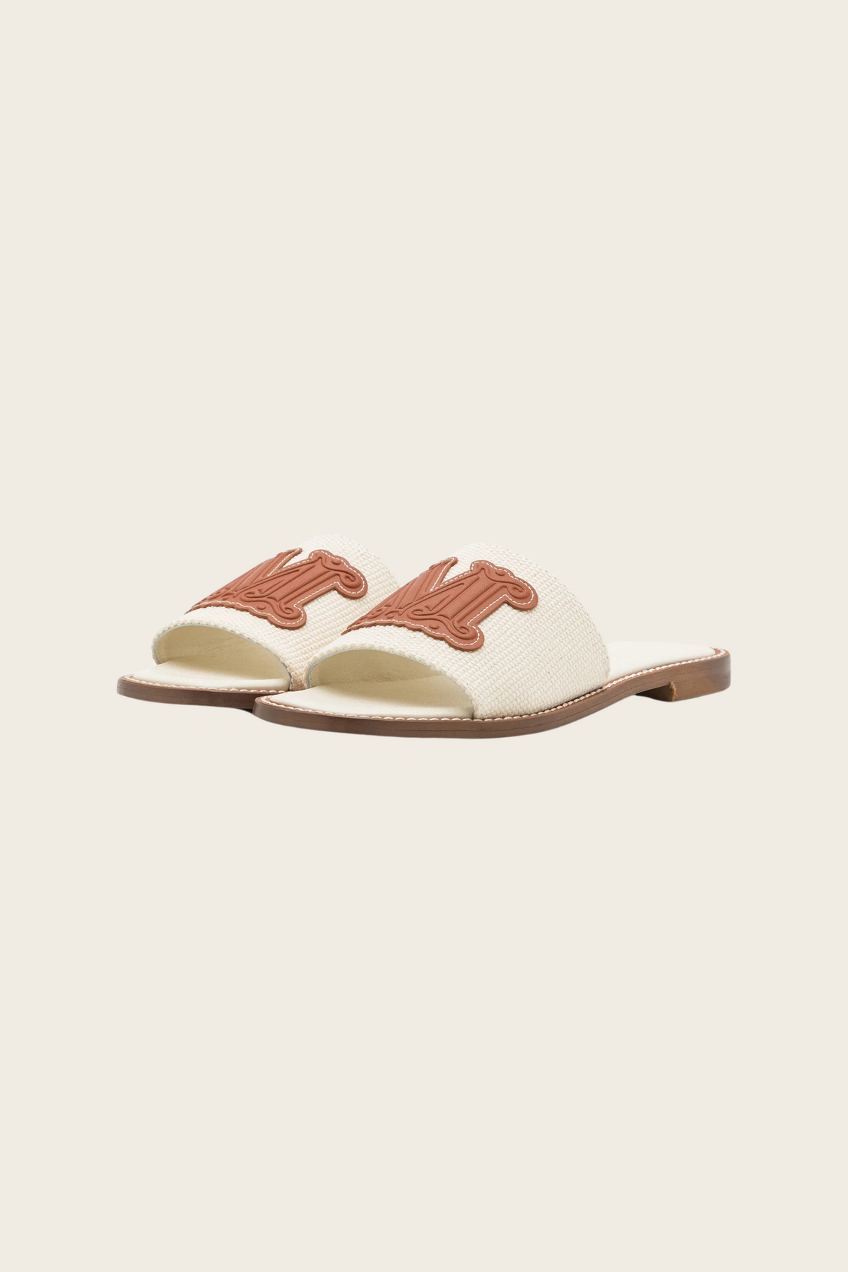 White Geneve slide sandals by MaxMara Beachwear, front angled view showing brown M logos and open toes