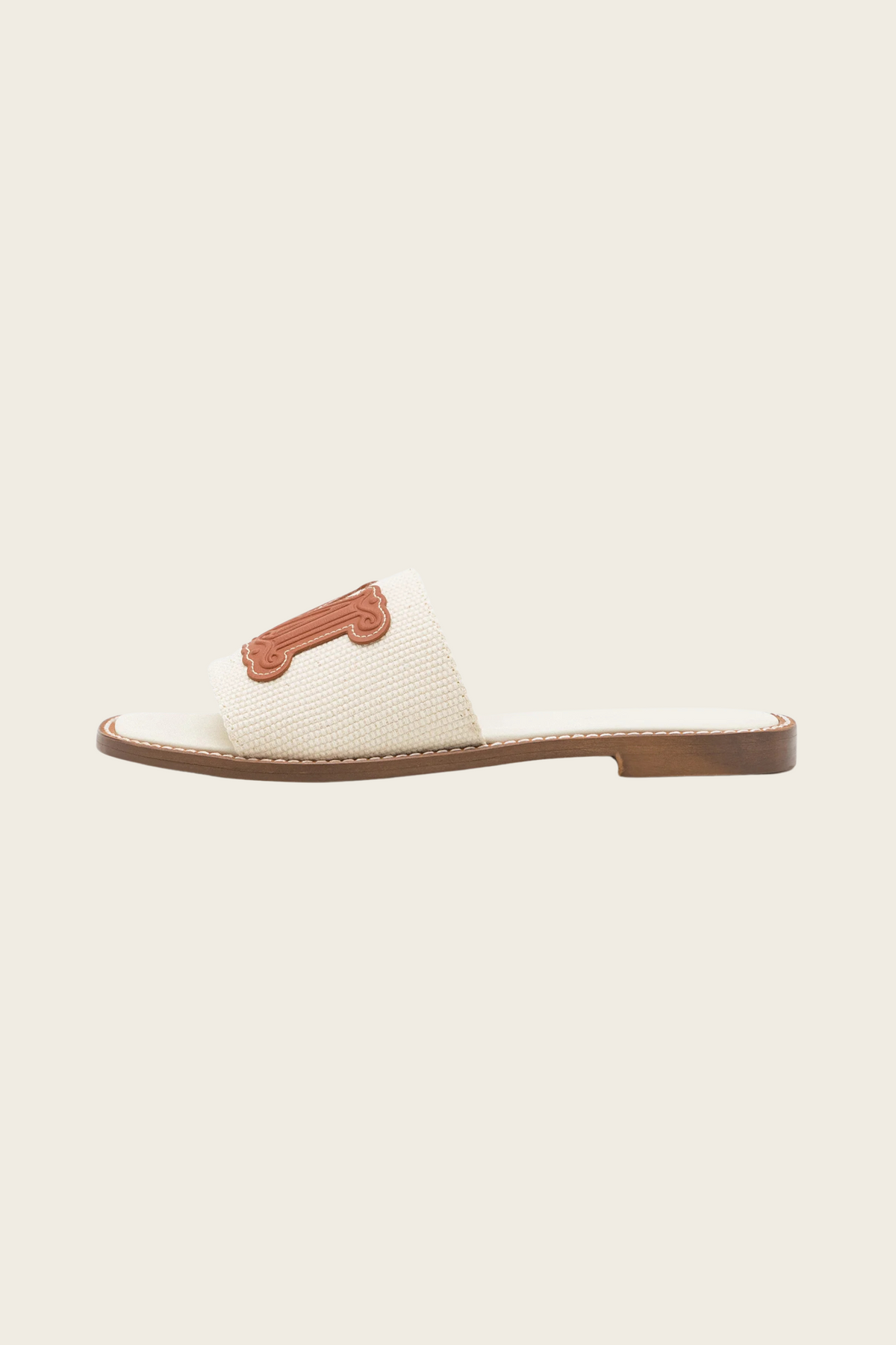 White Geneve slide sandal by MaxMara Beachwear, side view showing a textured strap and low heel
