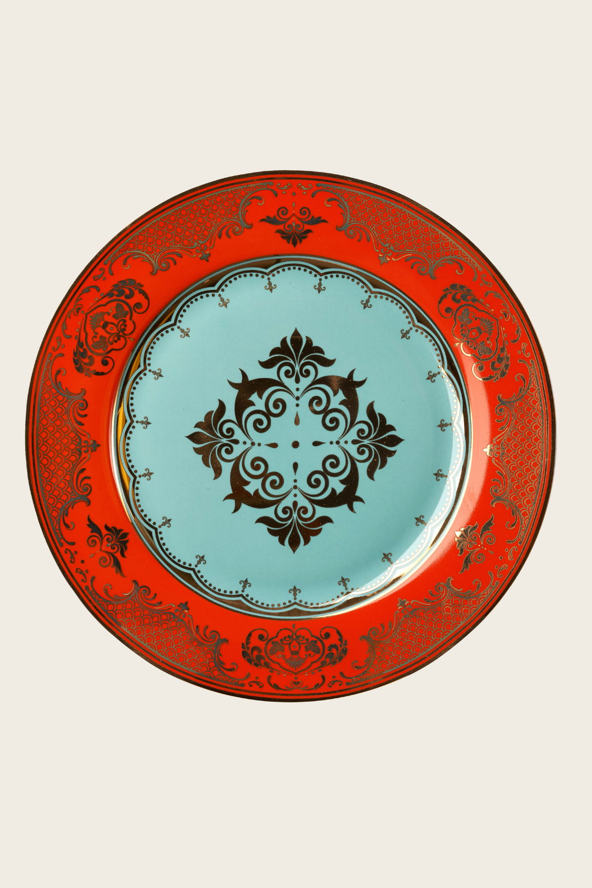 Turquoise-centred porcelain plate with a red rim and ornate black pattern