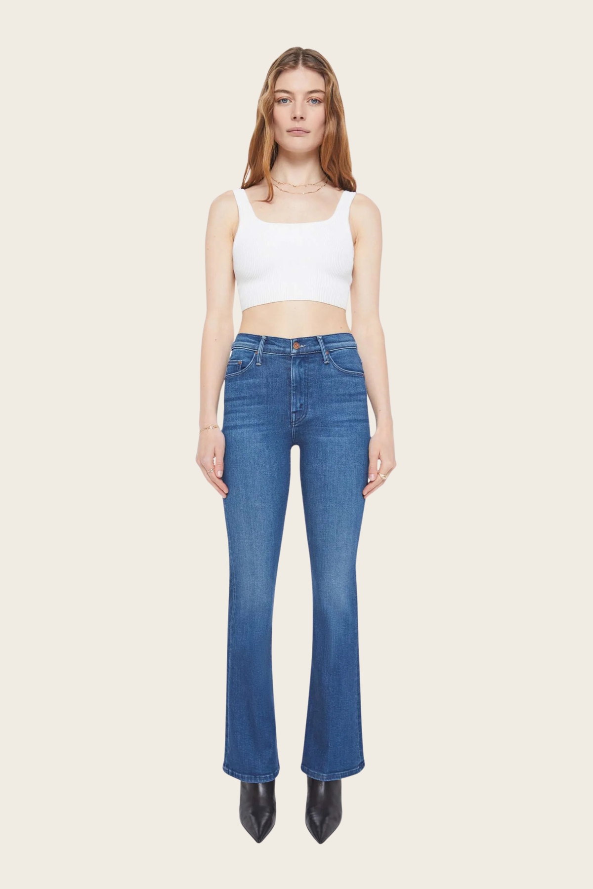 Blue denim jeans by Mother styled with a white tank top and black heeled boots.